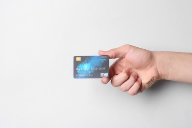 Photo of Man holding credit card on light grey background, closeup