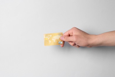 Photo of Man holding credit card on light grey background, closeup