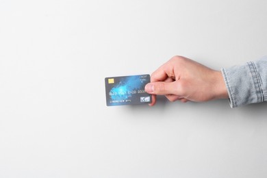 Photo of Man holding credit card on light grey background, closeup