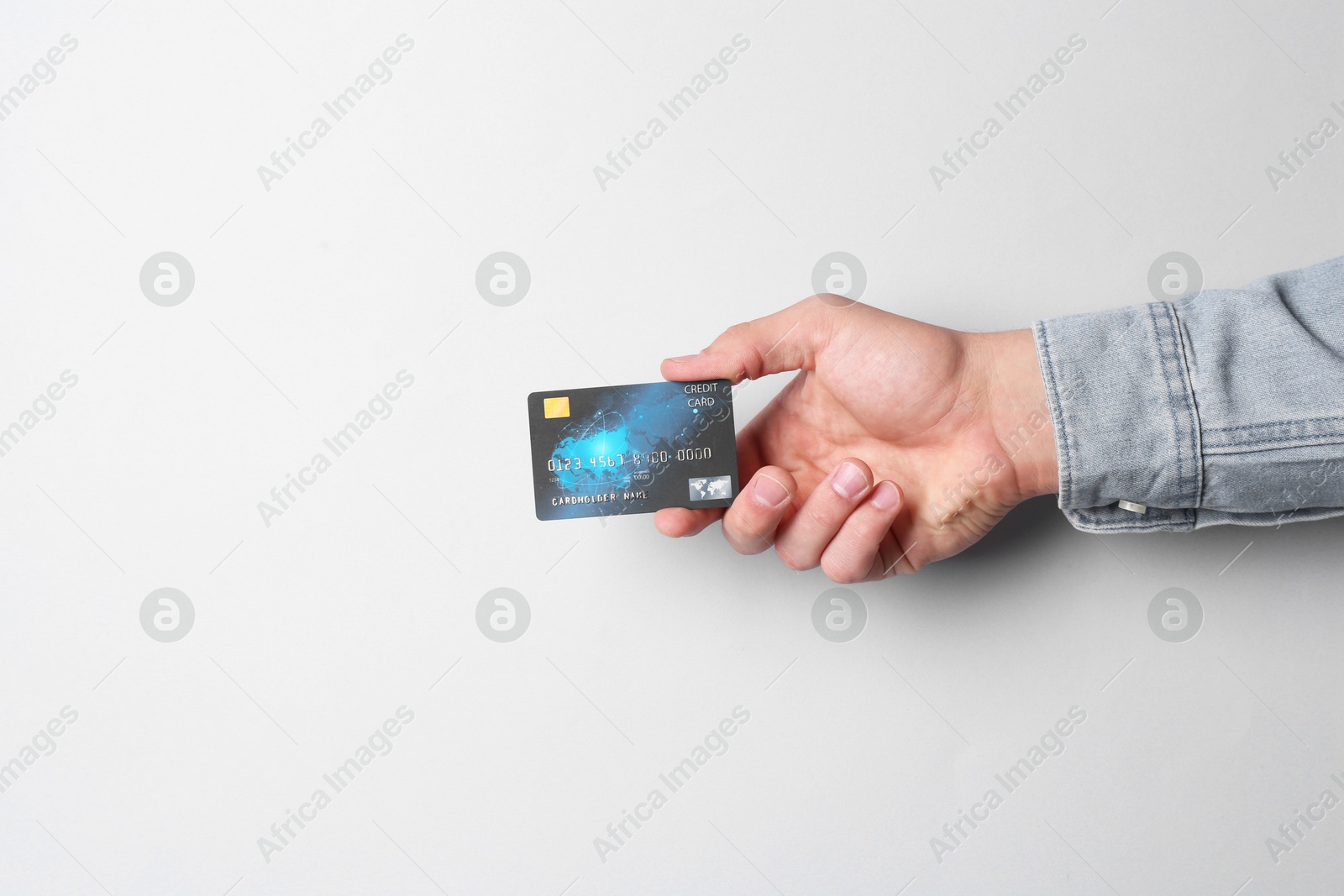 Photo of Man holding credit card on light grey background, closeup