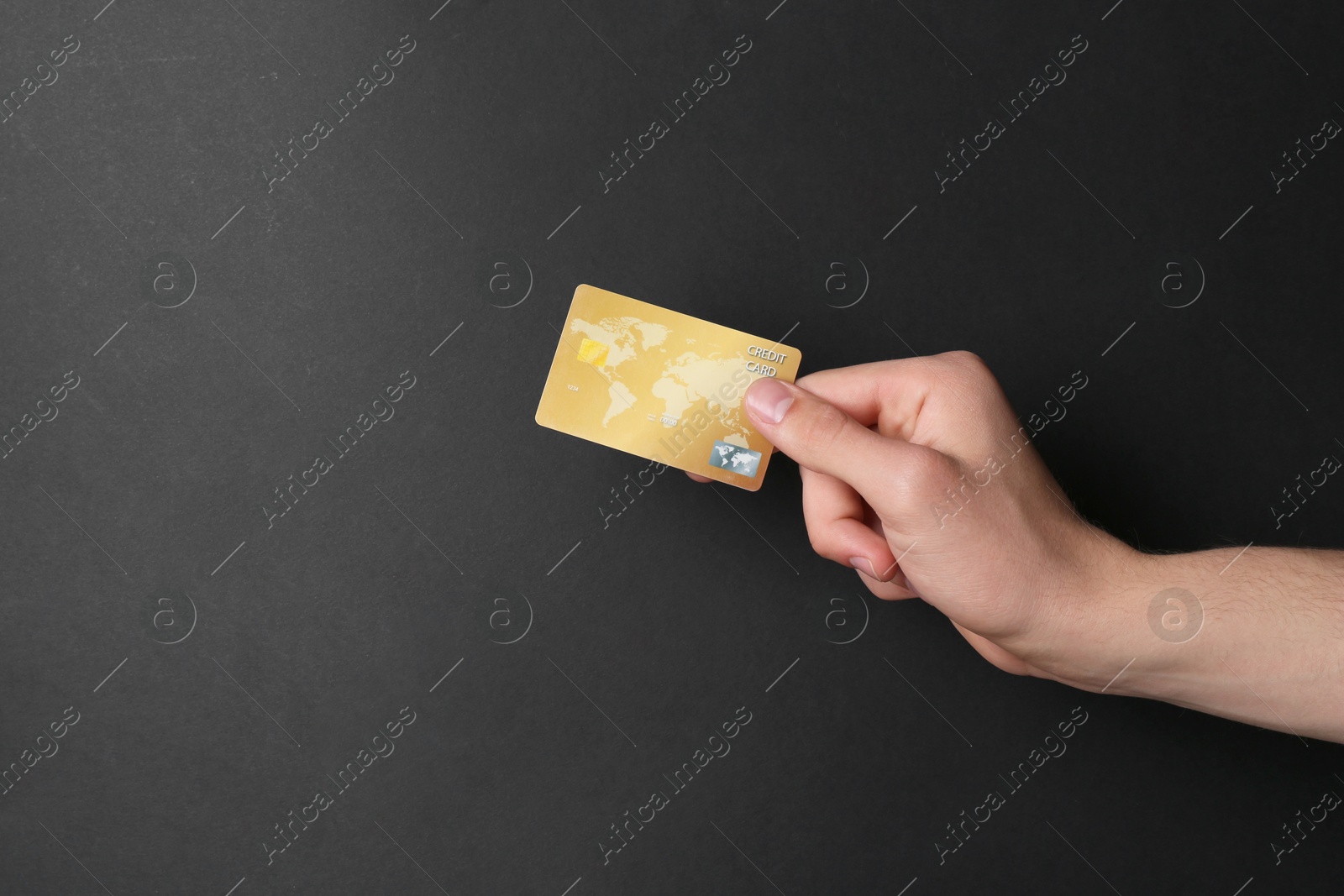 Photo of Man holding credit card on black background, closeup