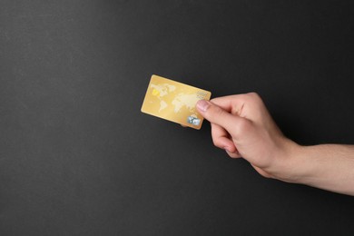 Photo of Man holding credit card on black background, closeup