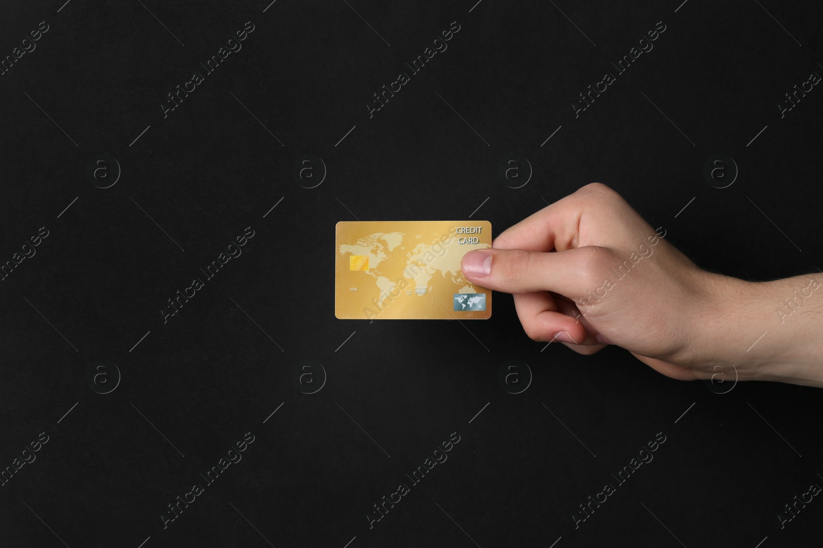 Photo of Man holding credit card on black background, closeup