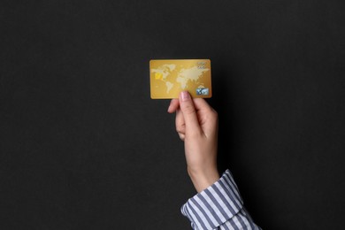 Photo of Woman holding credit card on black background, closeup