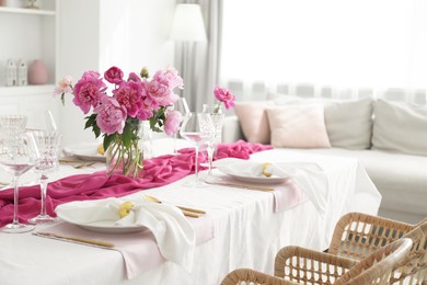 Photo of Beautiful table setting with pink peonies in dining room