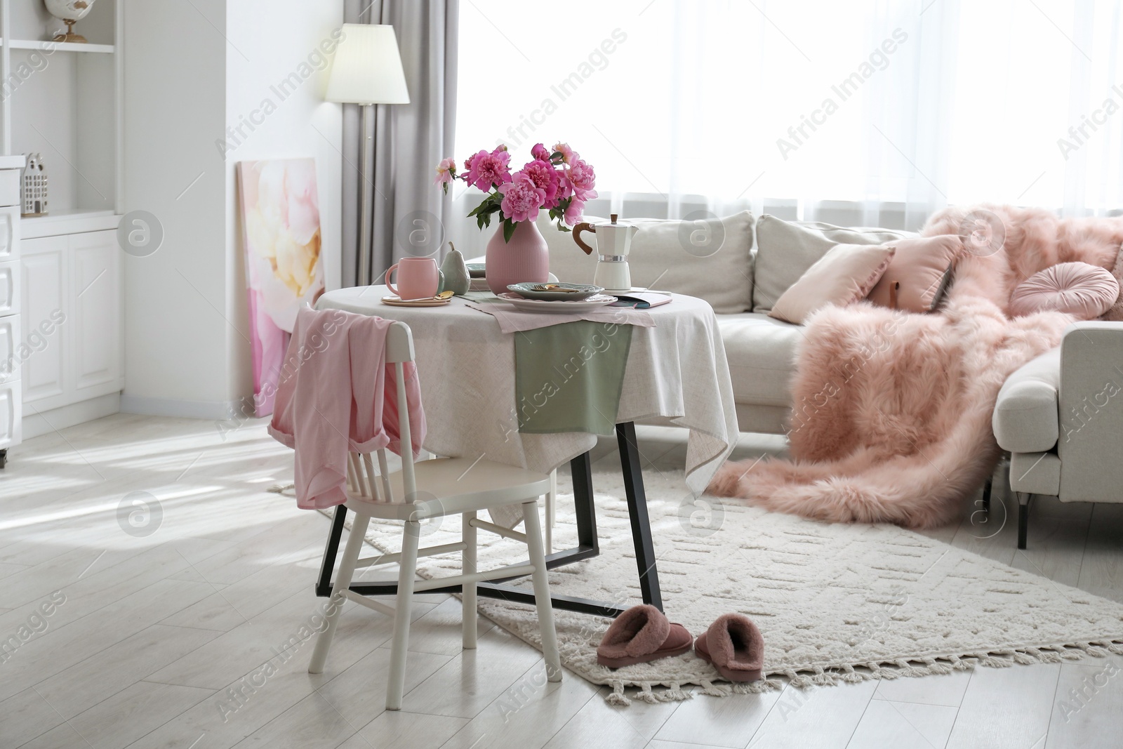 Photo of Beautiful table setting with pink peonies in living room