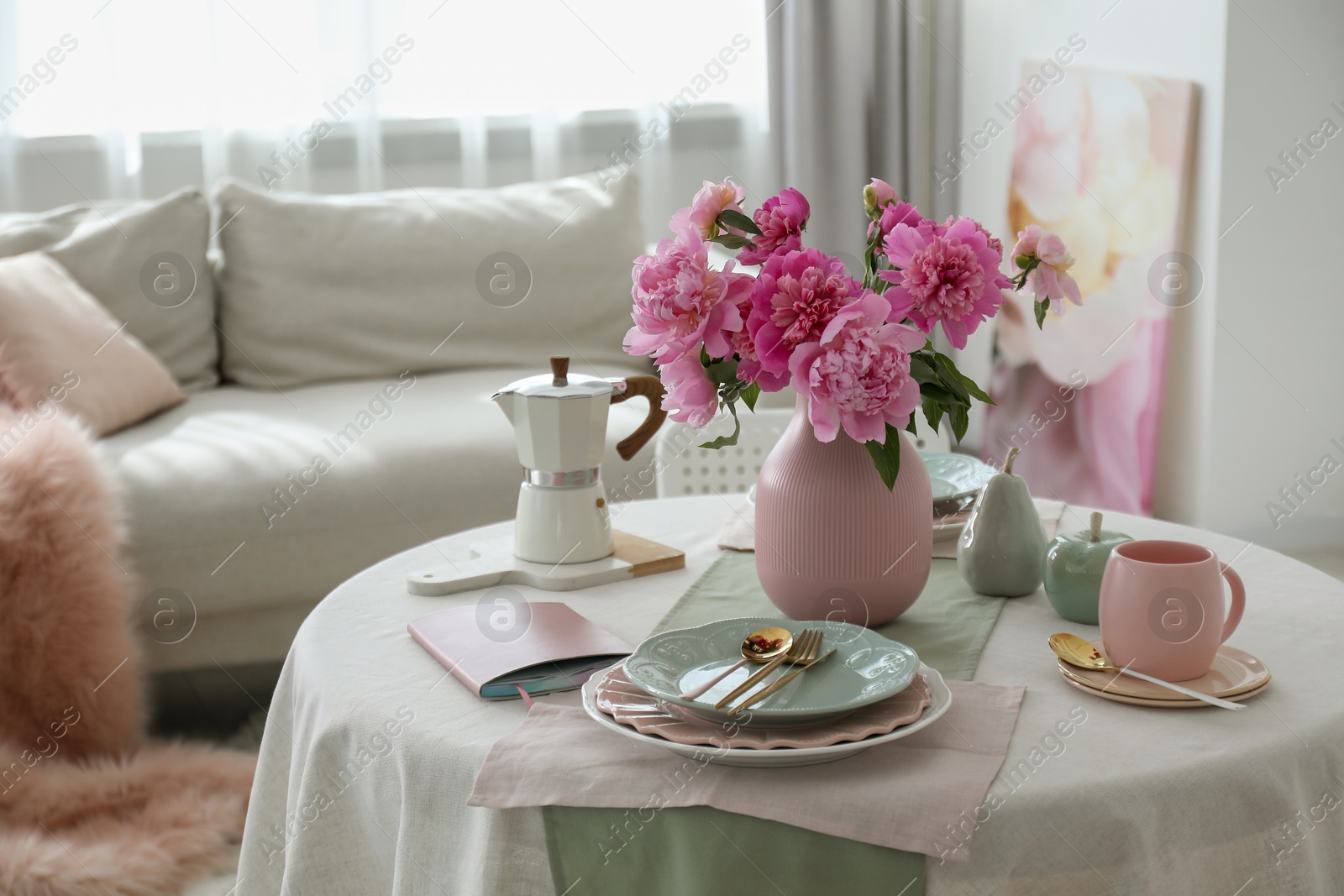 Photo of Beautiful table setting with pink peonies in living room