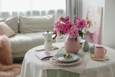 Beautiful table setting with pink peonies in living room