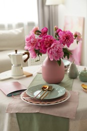 Photo of Beautiful table setting with pink peonies in dining room