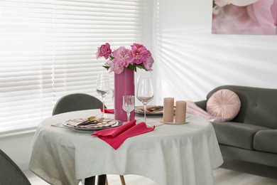 Beautiful table setting with pink peonies and candles