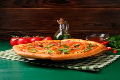 Photo of Delicious pizza Diablo and ingredients on green wooden table