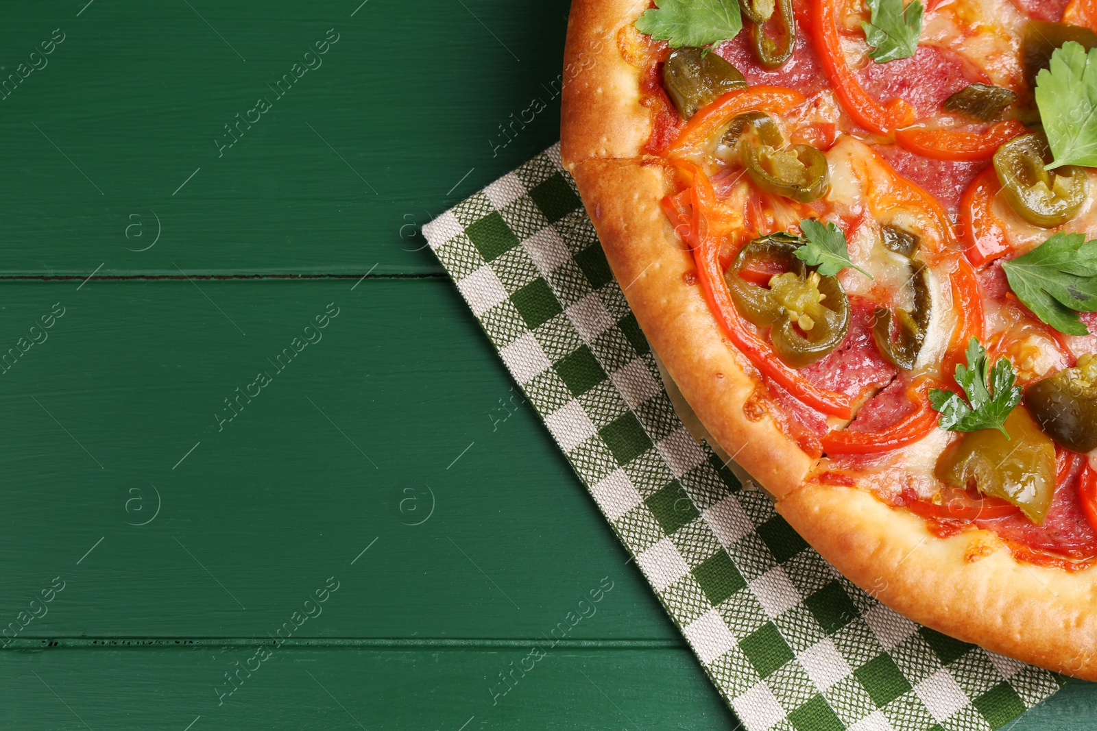 Photo of Delicious pizza Diablo on green wooden table, top view. Space for text