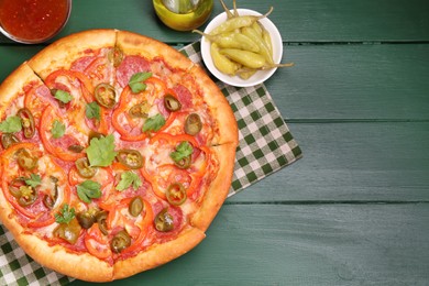 Delicious pizza Diablo and ingredients on green wooden table, flat lay. Space for text