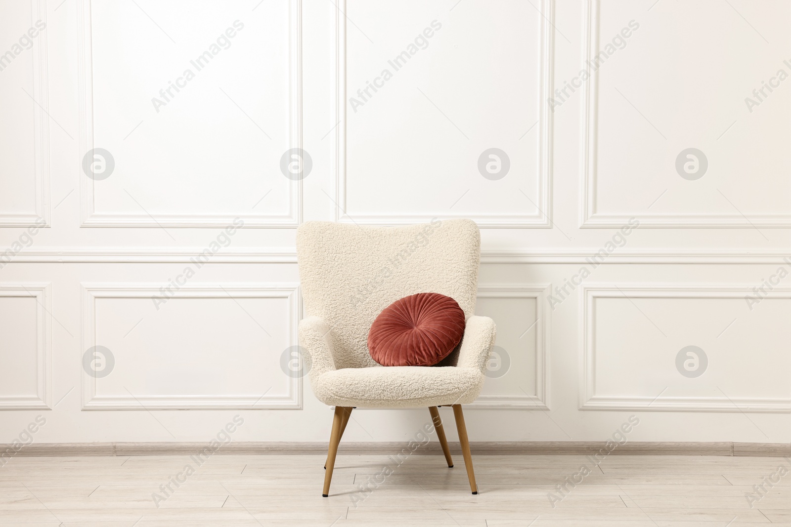 Photo of Soft armchair with pillow in light room