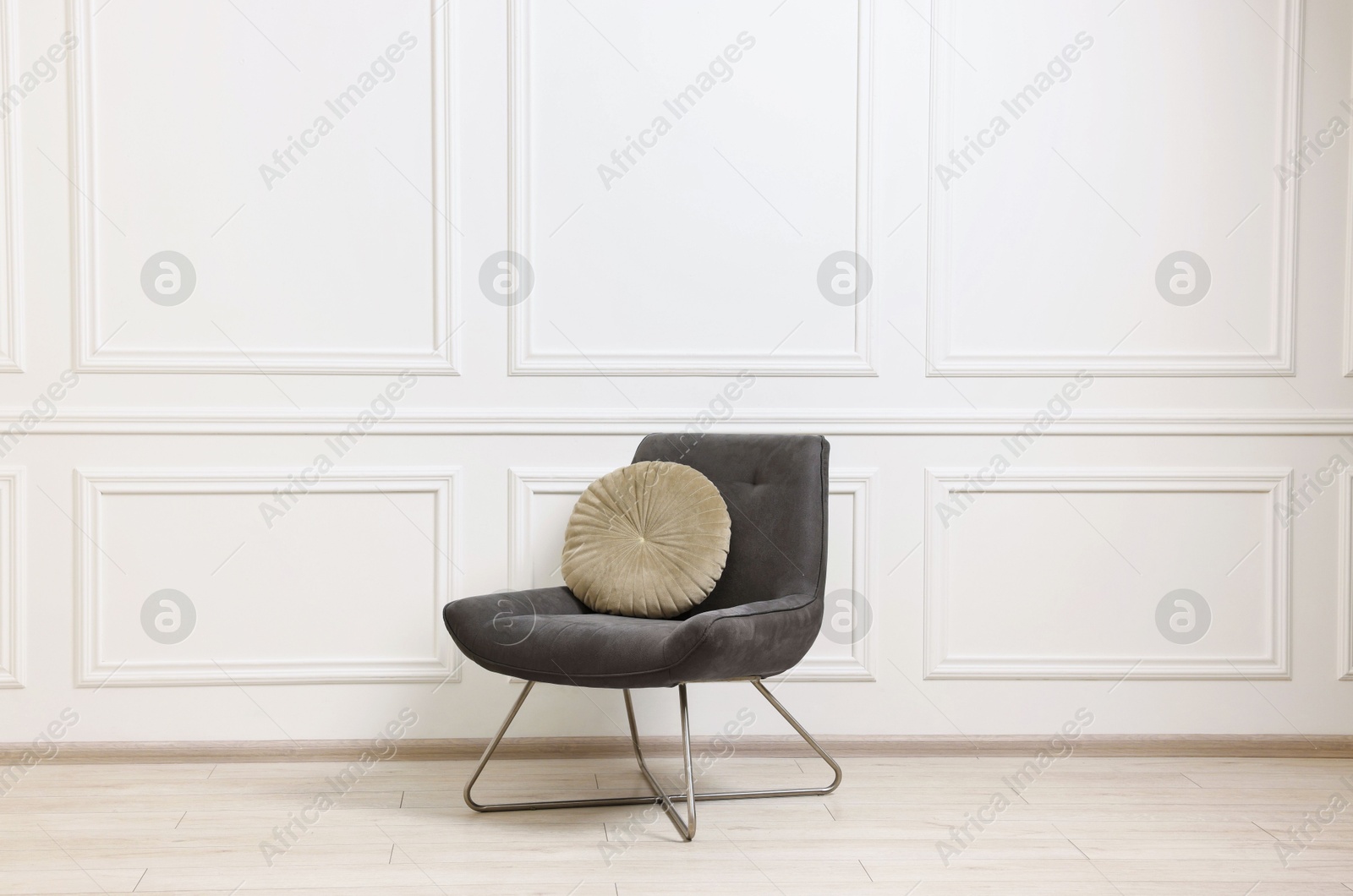 Photo of Soft armchair with pillow in light room