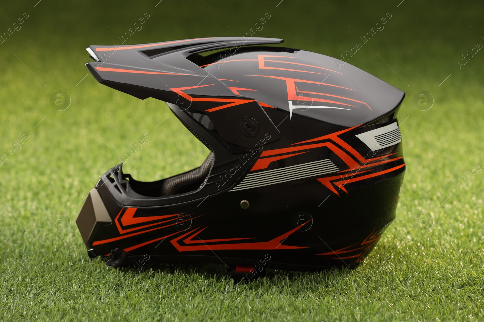 Photo of Modern motorcycle helmet with visor on green grass