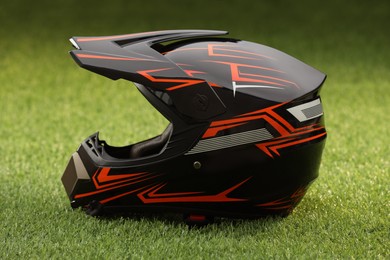 Photo of Modern motorcycle helmet with visor on green grass