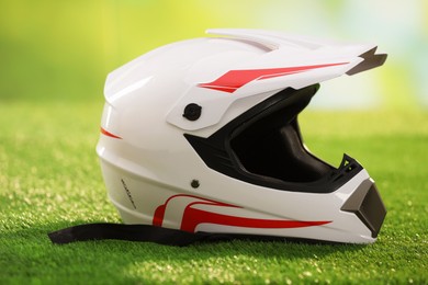 Photo of Modern motorcycle helmet with visor on green grass