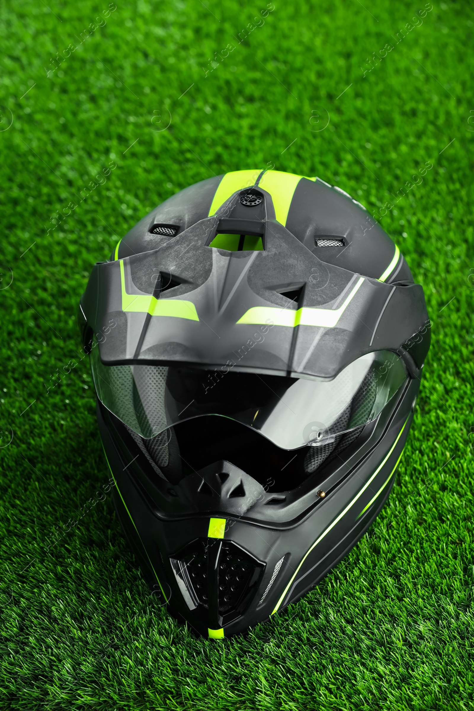 Photo of Modern motorcycle helmet with visor on green grass