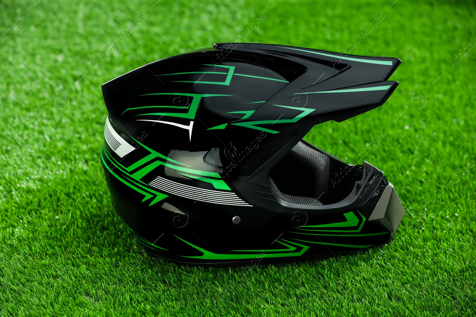 Photo of Modern motorcycle helmet with visor on green grass