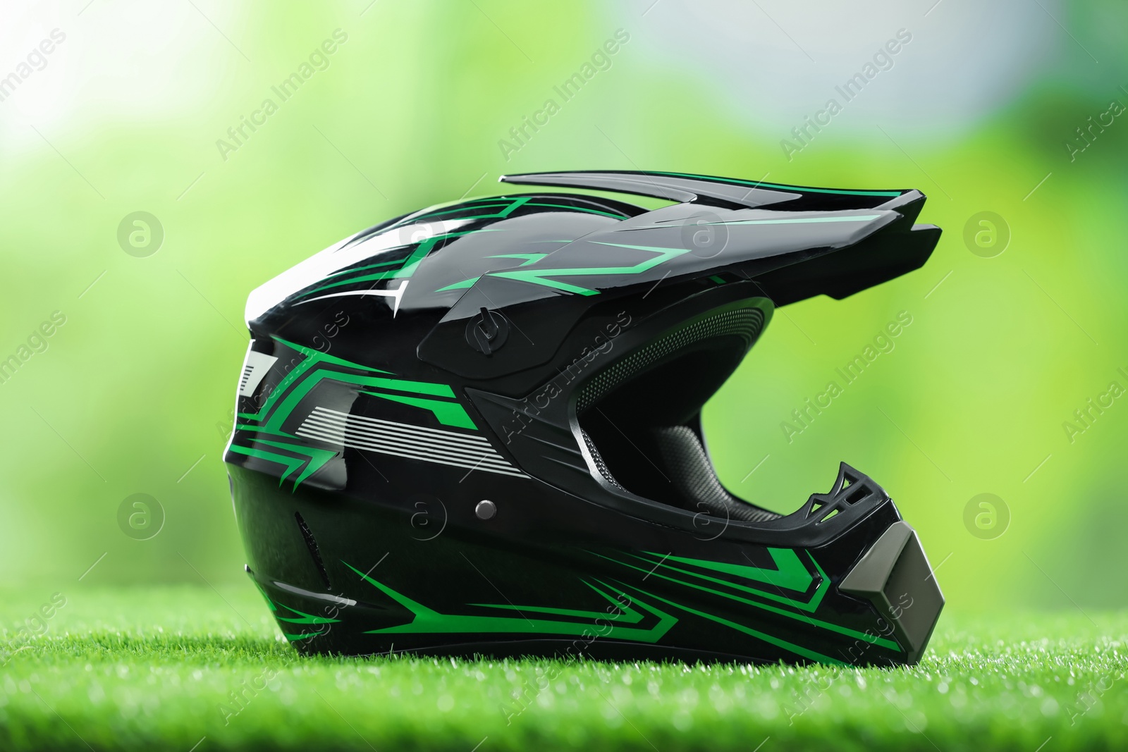 Photo of Modern motorcycle helmet with visor on green grass