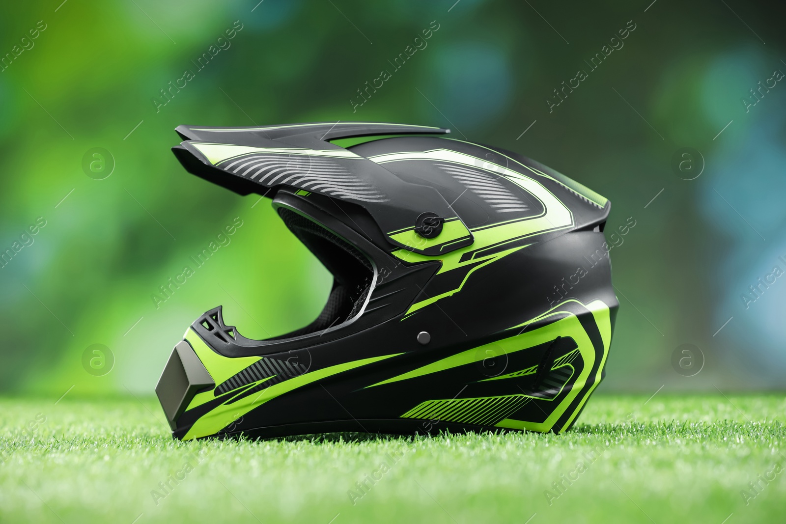 Photo of Modern motorcycle helmet with visor on green grass