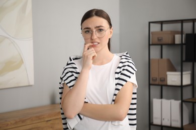 Photo of Portrait of embarrassed woman in glasses in office