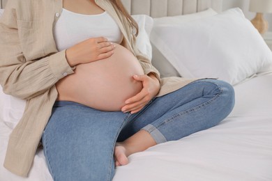 Photo of Pregnant woman on bed at home, closeup