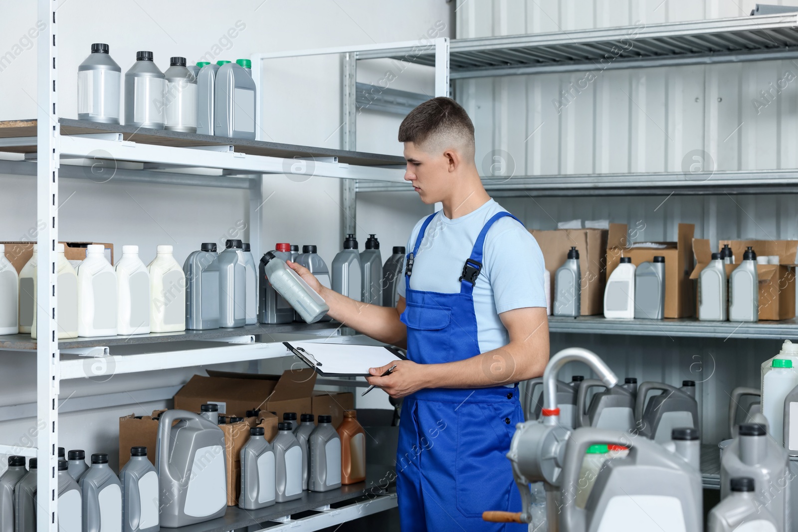 Photo of Man with clipboard and different car products in auto store