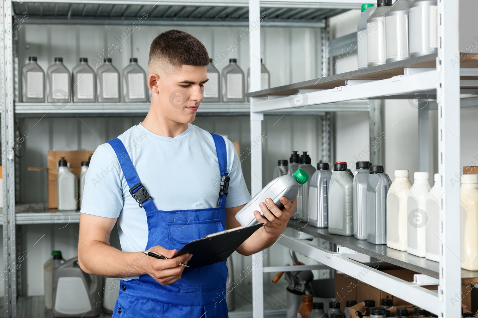 Photo of Young man with clipboard and different car products in auto store