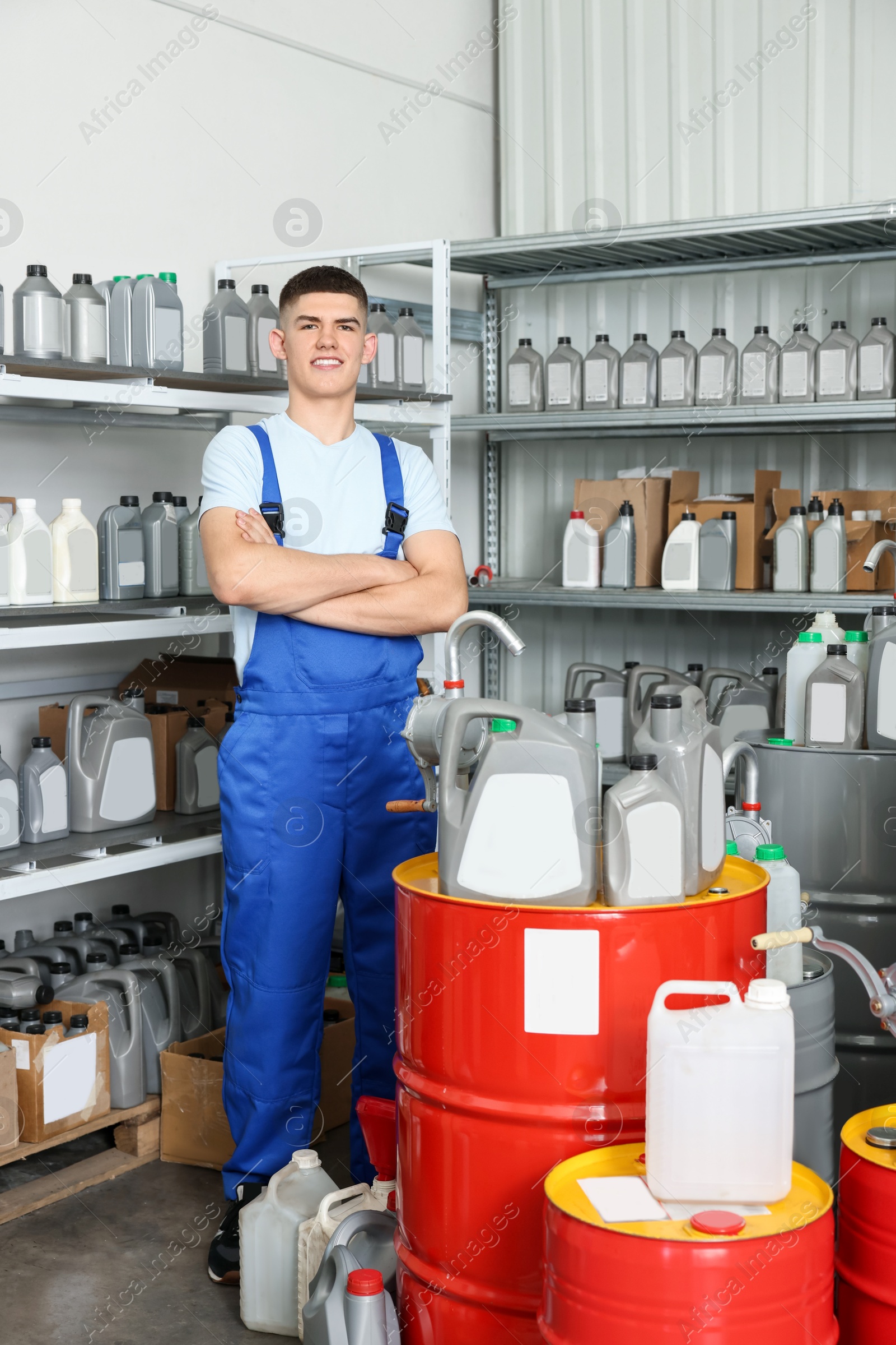 Photo of Smiling young man in auto store with different car products