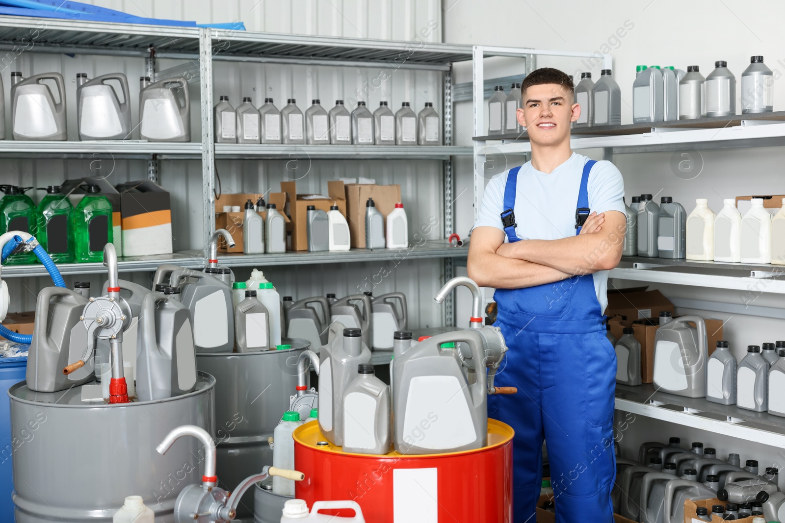 Photo of Smiling young man in auto store with different car products