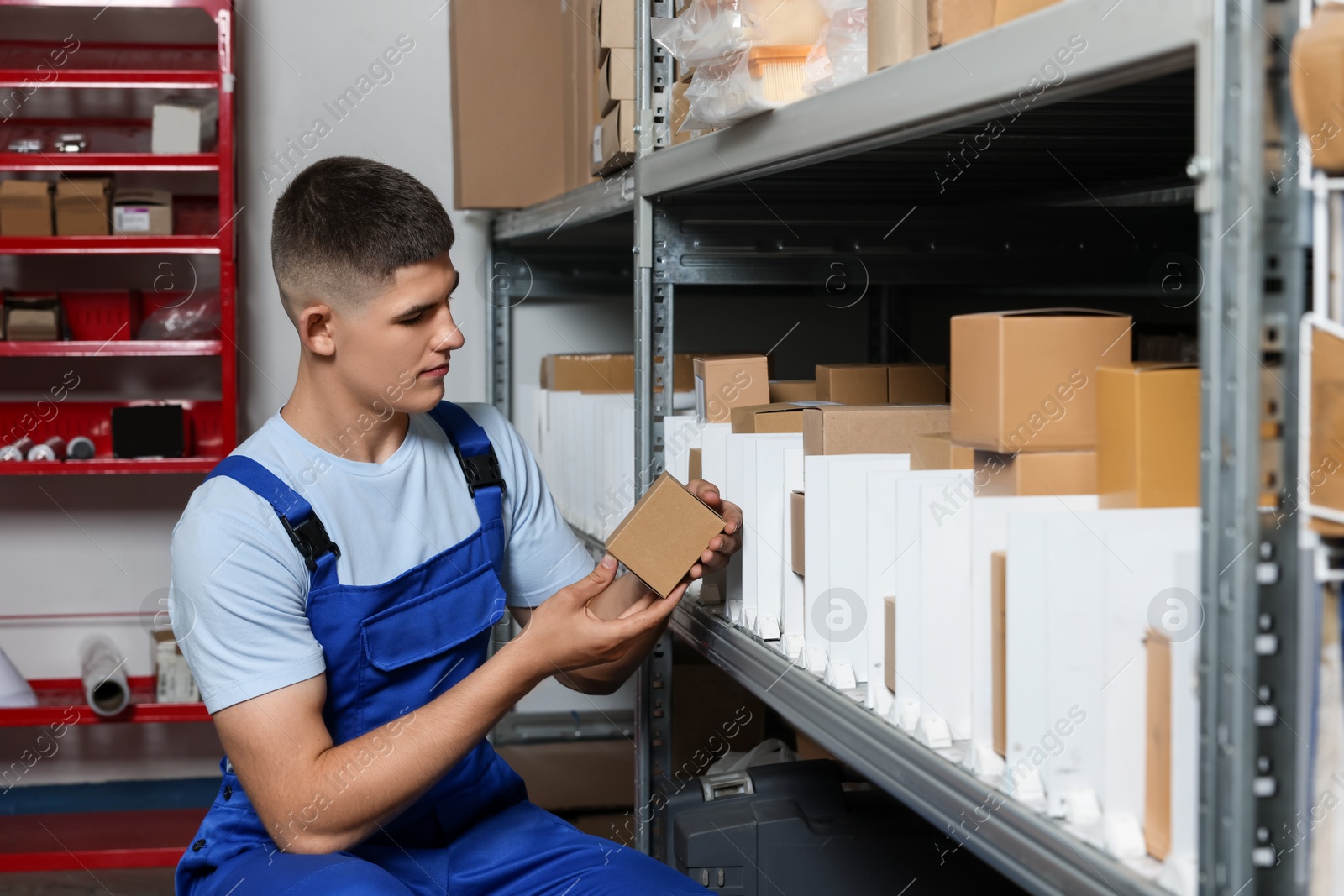 Photo of Young man with many cardboard boxes in auto store