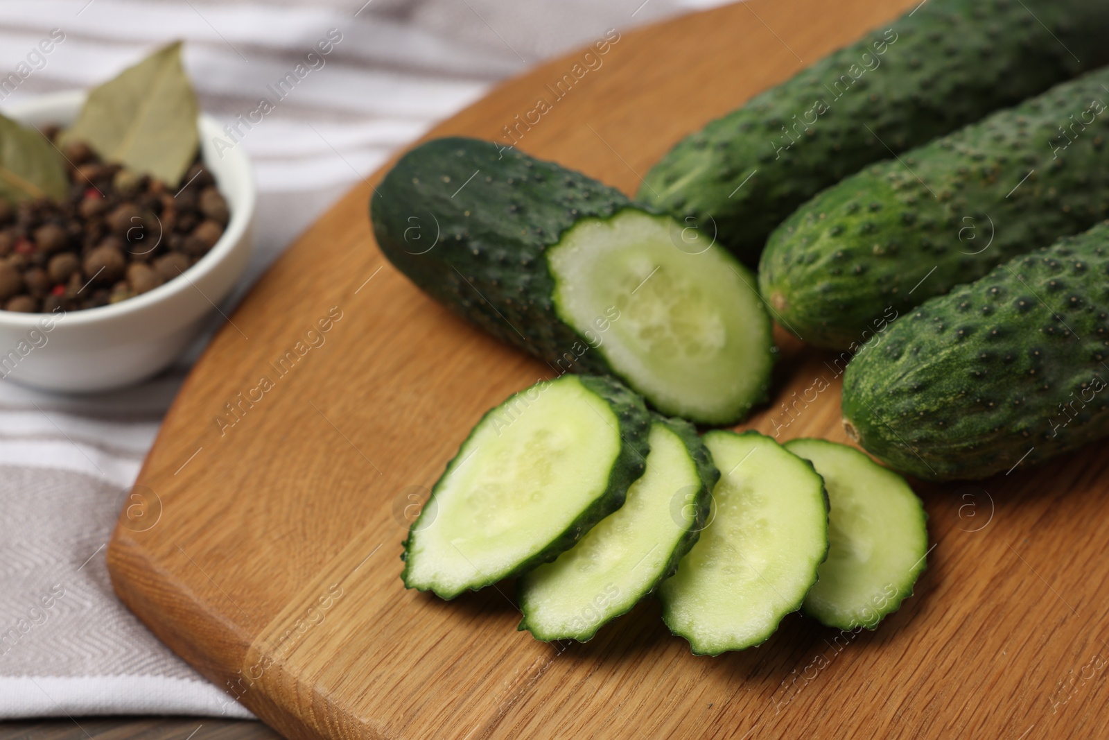 Photo of Fresh whole and cut cucumbers on table, closeup