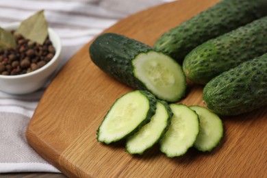 Photo of Fresh whole and cut cucumbers on table, closeup