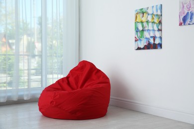 Photo of Red bean bag chair near window in room