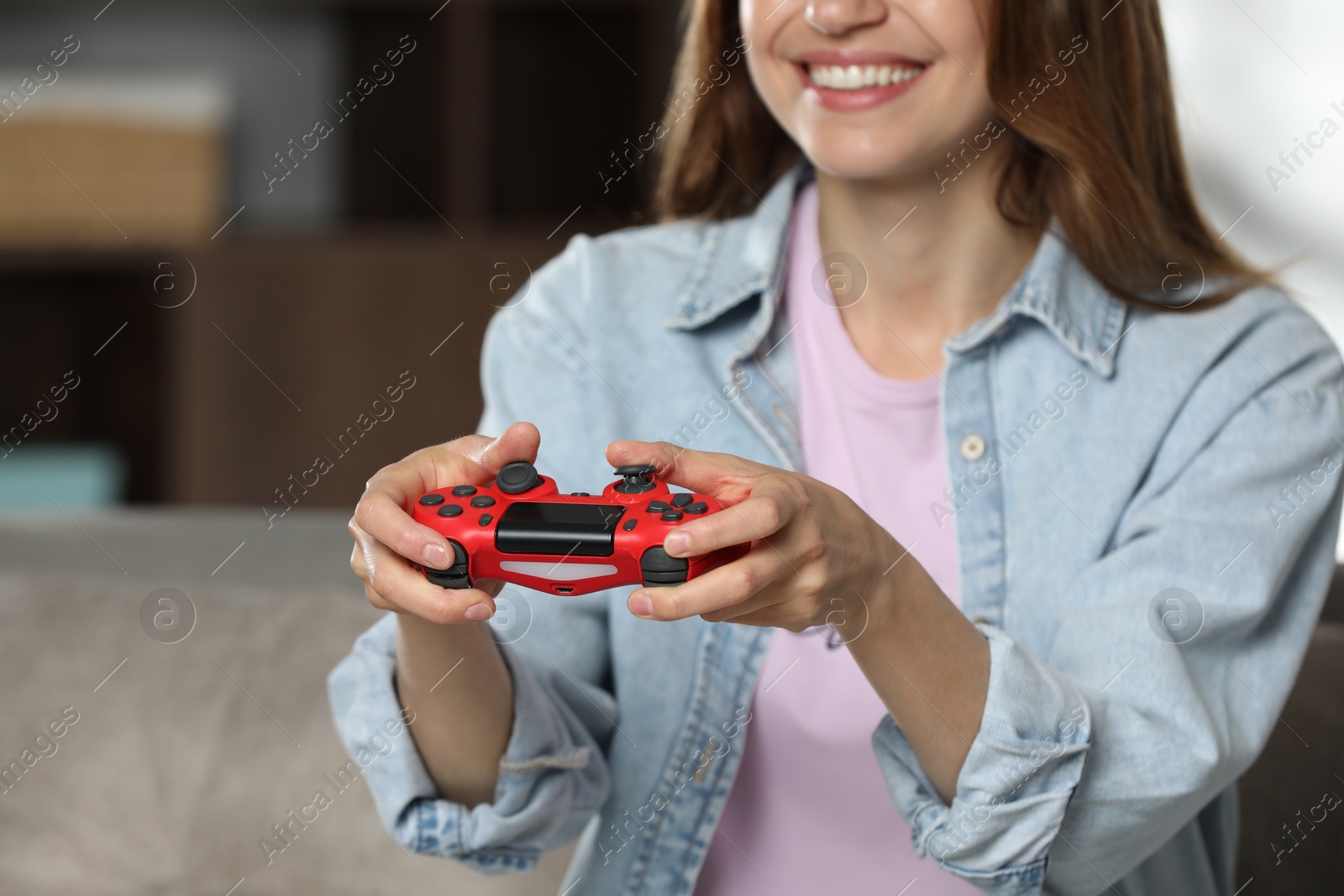 Photo of Smiling woman playing video game with controller at home, closeup