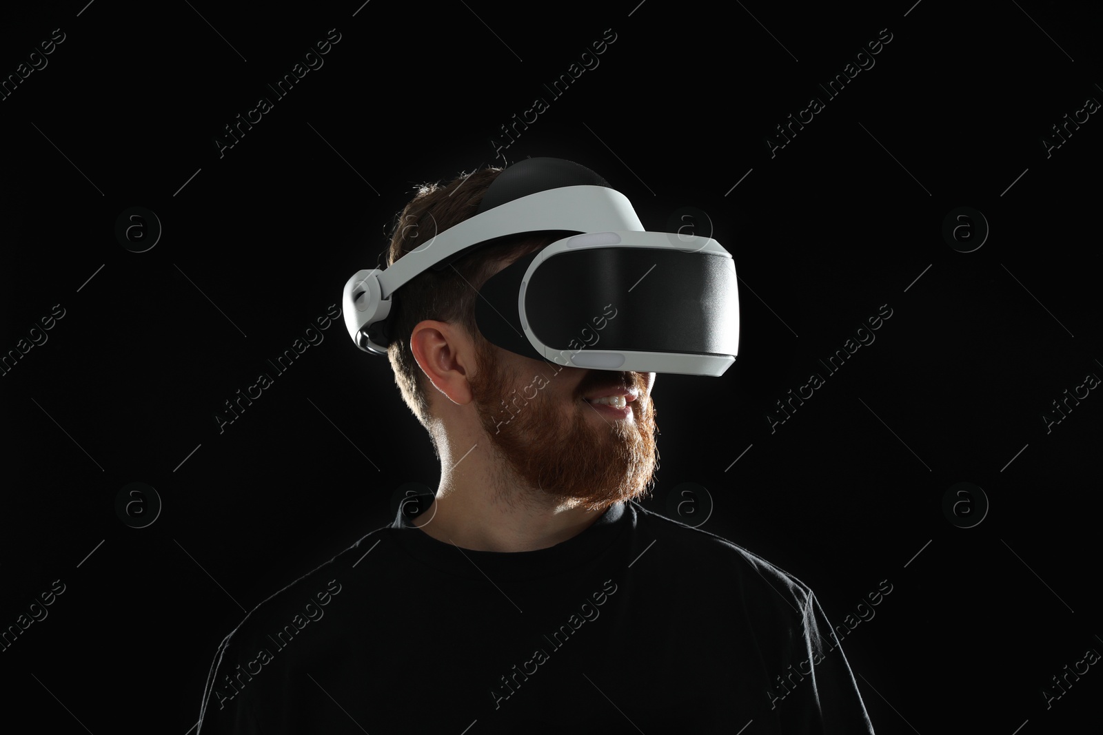 Photo of Man using virtual reality headset on black background