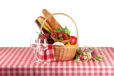 Photo of Picnic wicker basket with checkered napkin, food and bottle of wine on table against white background