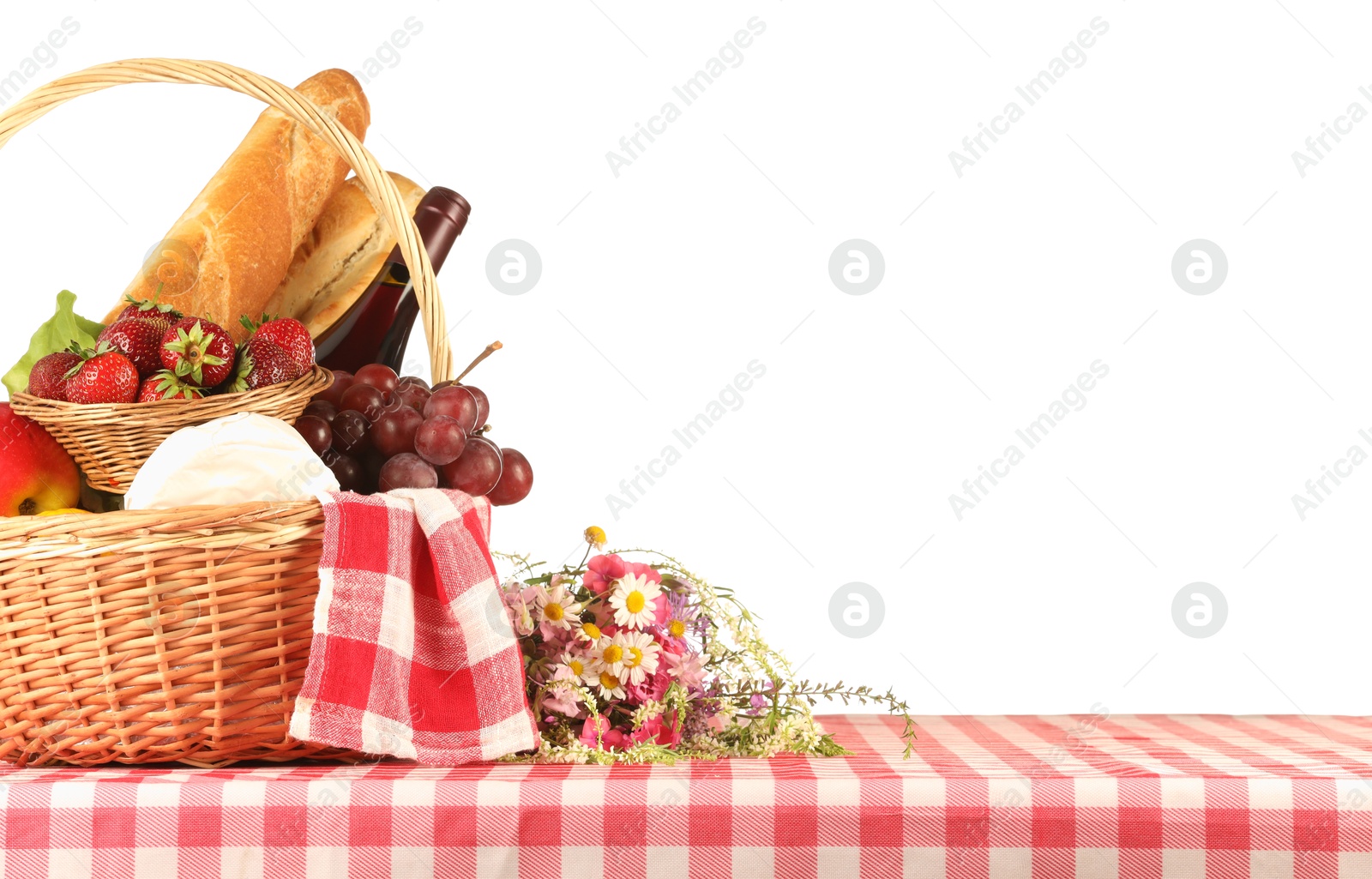 Photo of Picnic wicker basket with checkered napkin, food and bottle of wine on table against white background. Space for text