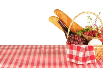 Photo of Picnic wicker basket with checkered napkin, food and bottle of wine on table against white background. Space for text