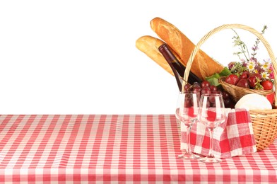 Picnic wicker basket with checkered napkin, food and bottle of wine on table against white background. Space for text