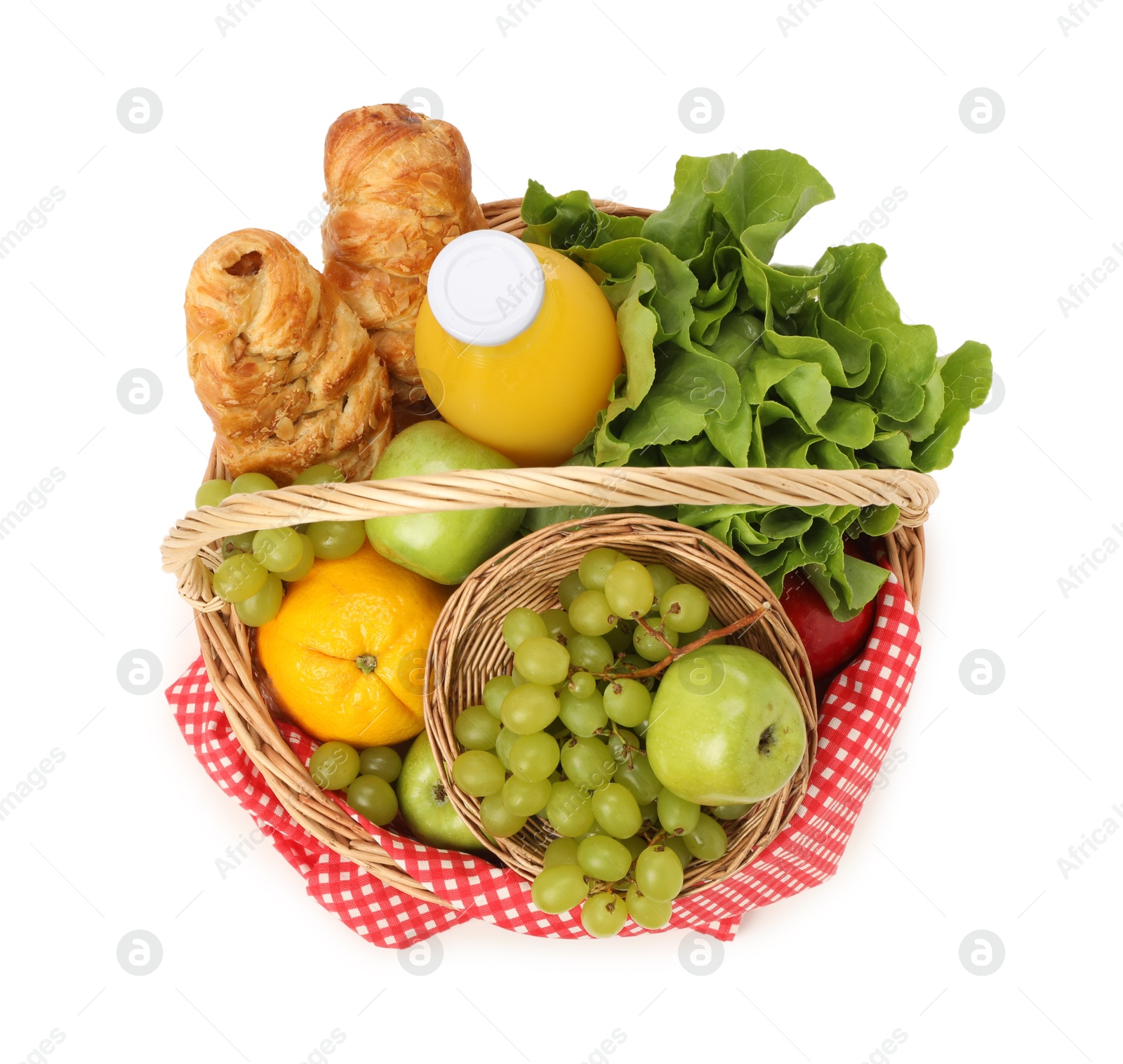 Photo of Picnic basket with checkered napkin, food and juice isolated on white, top view