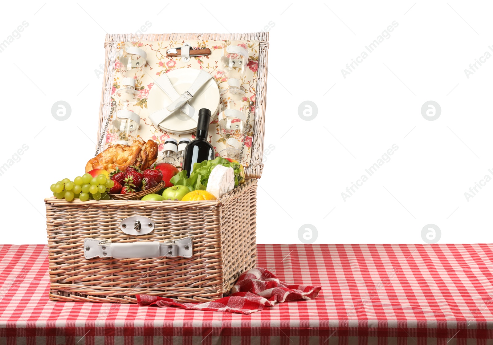 Photo of Picnic wicker basket with food, tableware and bottle of wine on table against white background. Space for text