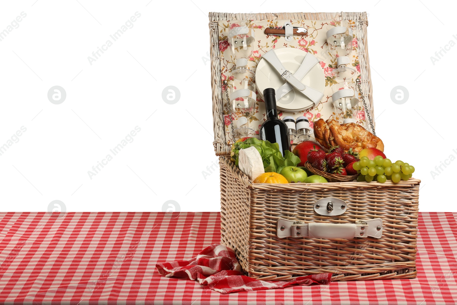 Photo of Picnic wicker basket with food, tableware and bottle of wine on table against white background. Space for text