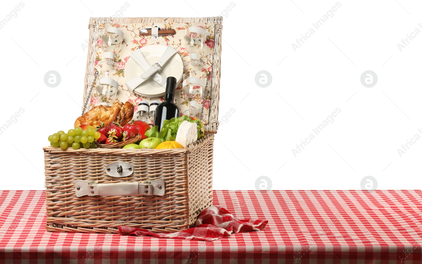 Photo of Picnic wicker basket with food, tableware and bottle of wine on table against white background. Space for text