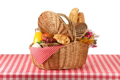 Photo of Picnic wicker basket with food, bottle of juice and flowers on table against white background