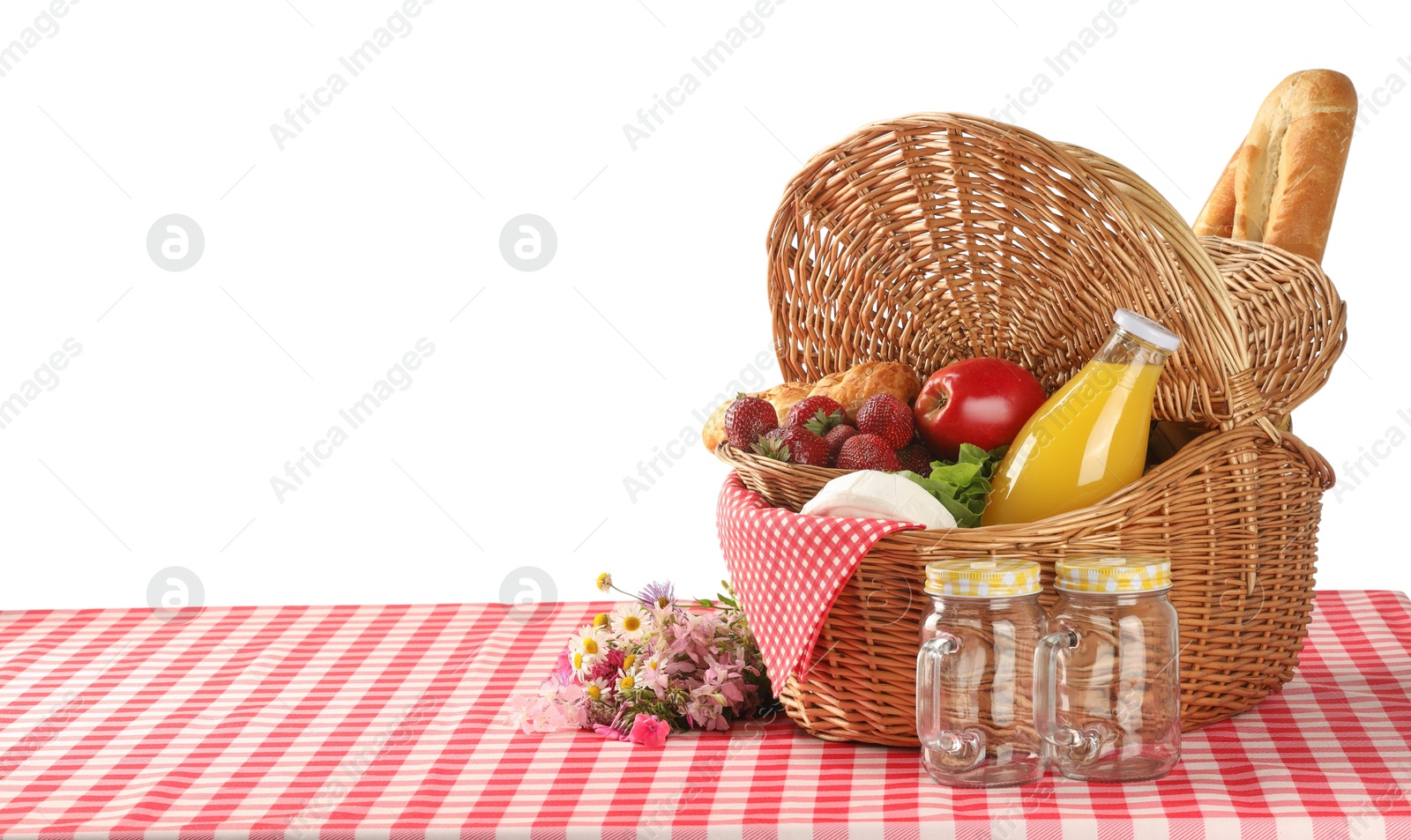 Photo of Picnic wicker basket with food, bottle of juice and flowers on table against white background. Space for text