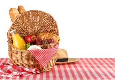 Photo of Picnic wicker basket with food, bottle of juice, napkin and hat on table against white background. Space for text