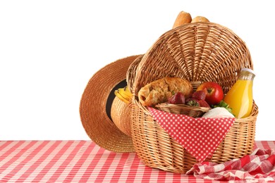 Photo of Picnic wicker basket with food, bottle of juice, napkin and hat on table against white background. Space for text